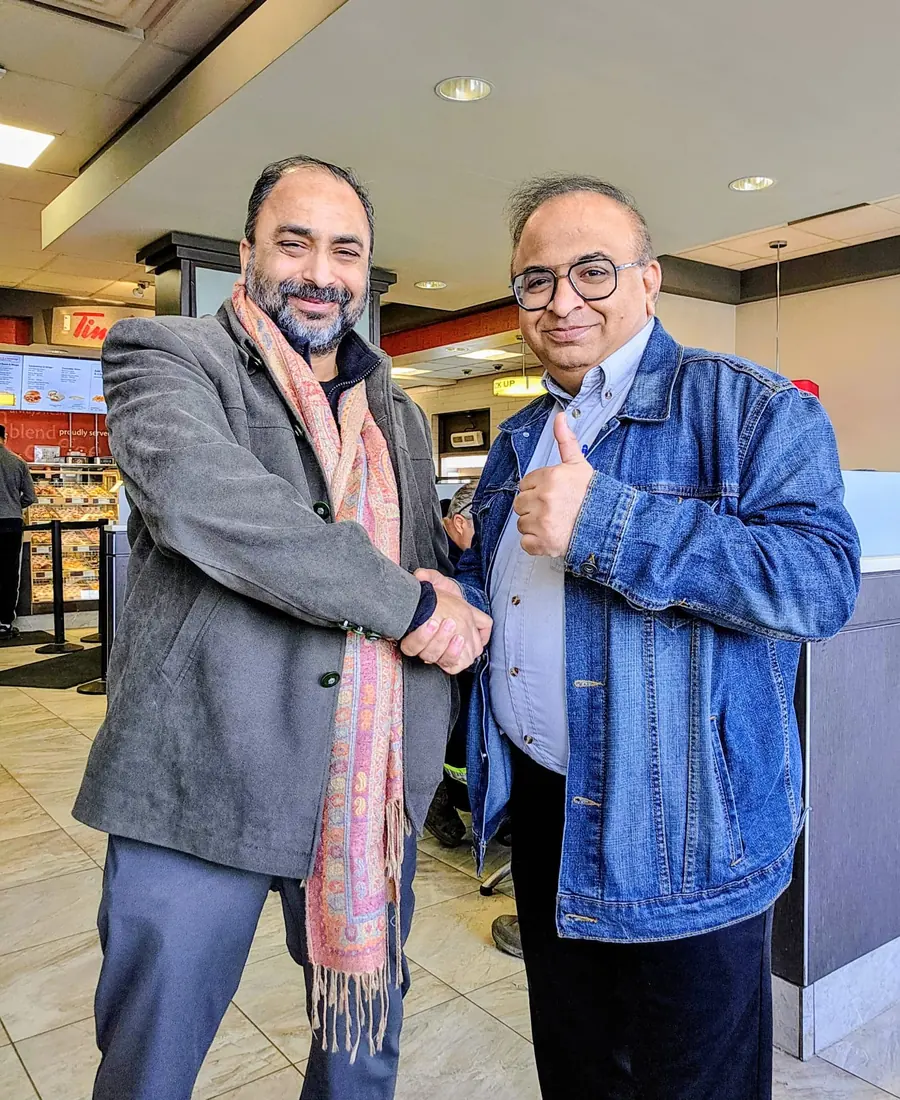 Husain greeting a supporter at a local coffee shop