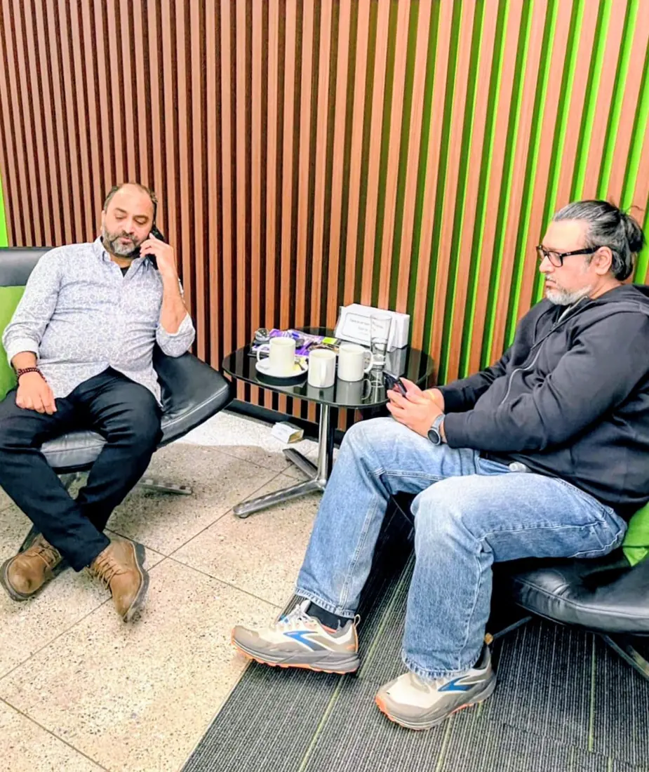 Husain on a call with a colleague in a lounge