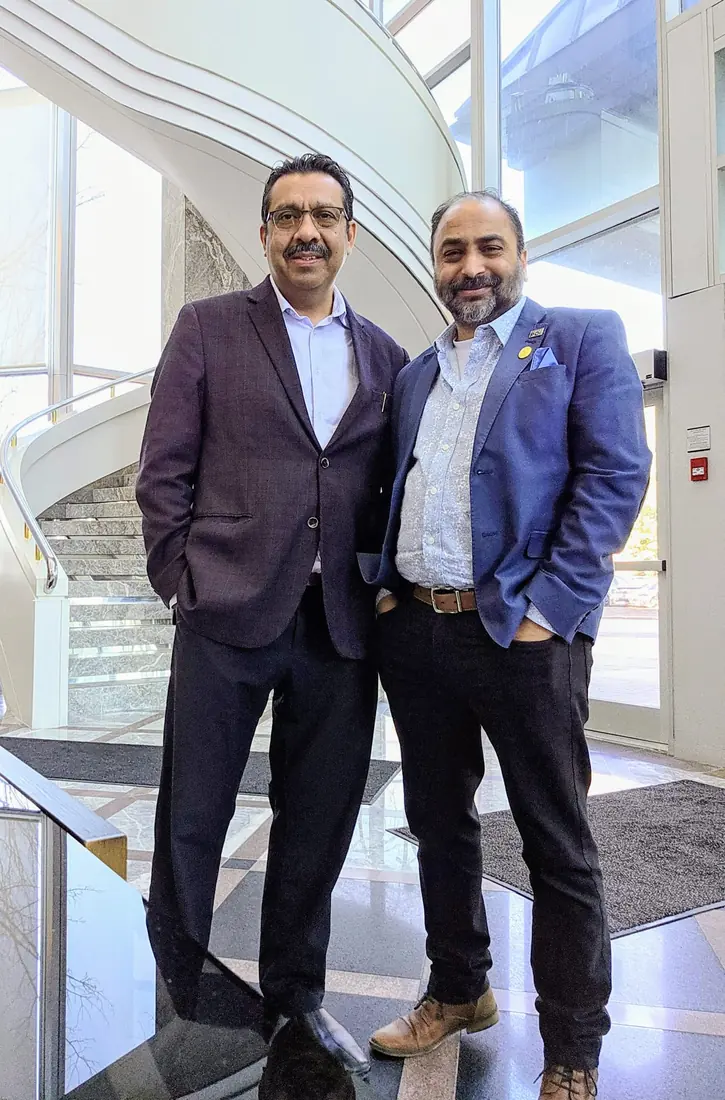 Husain with a community leader in a building lobby